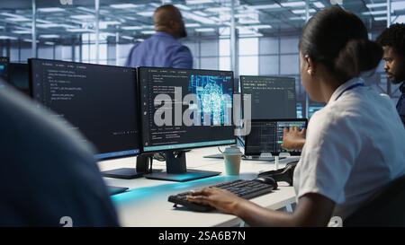 Engineer in data center implementing advanced AI driven predictive maintenance systems to proactively identify and resolve potential hardware failures before they impact operations, camera A Stock Photo