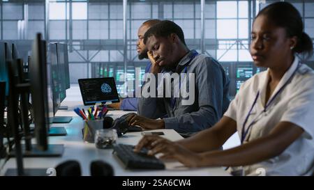 Tired data center engineer yawning, suffering from lack of sleep while maintaining company network infrastructure. Bored server hub worker feeling fatigued, struggling to stay awake, camera A Stock Photo