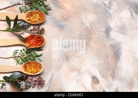 Wooden spoons with pills and fresh plants on grunge background Stock Photo