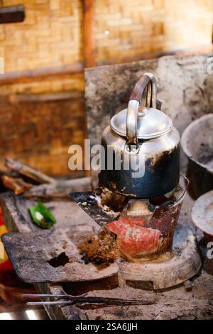 Vintage old kettle on fire stove in Asian house Stock Photo