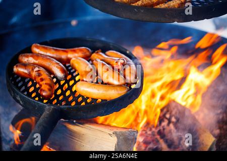 Sausages grilled over open fire outdoors Stock Photo