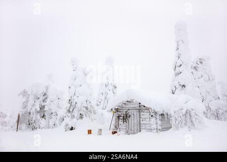 Snow covered log cabin in majestic winter forest in Lapland Finland Stock Photo