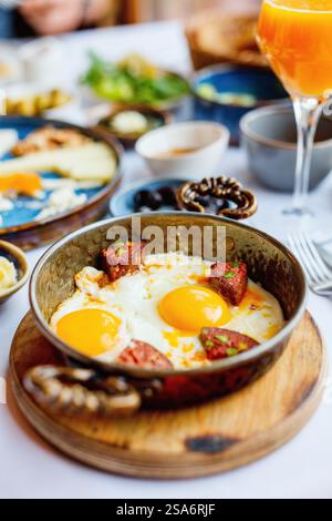 Delicious breakfast with fried eggs and turkish sausage served in pan Stock Photo
