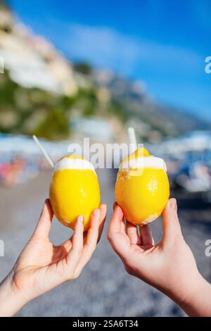 Close up of two hands holding fresh lemons filled with sorbet Stock Photo