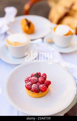 Close up of delicious raspberry tart dessert with fresh berries served at cafe or restaurant Stock Photo