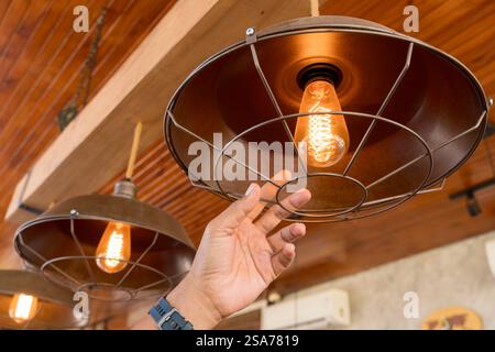 Close up hand change to led bulb in home. Concept for home improvement and green house. Close up of female hands installing eco light bulb. Stock Photo