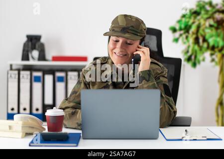 Pretty American soldier behind her computer talking on the phone in the office Stock Photo
