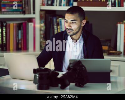 Laptop, videographer and business man in home office for video editing, remote work or creative project. Technology, photographer and freelancer on Stock Photo