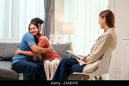 asian couple embraces happily after a productive counseling session with a therapist Stock Photo