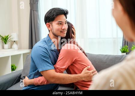 asian couple embraces happily after a productive counseling session with a therapist Stock Photo