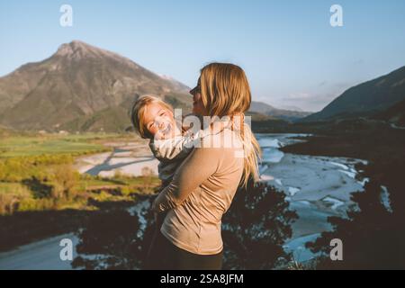 Mother walking with daughter family vacations together travel outdoor parent and child girl happy emotions mountains landscape Stock Photo