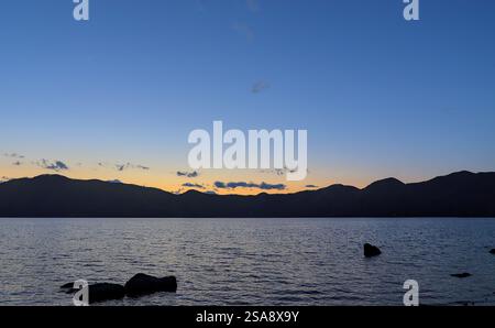 Looking out from the southwestern shoreline of Lake Motosu in Japan just after sunset on a clear day in early summer Stock Photo