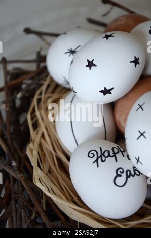 White marker decorated Easter eggs in the nest Stock Photo