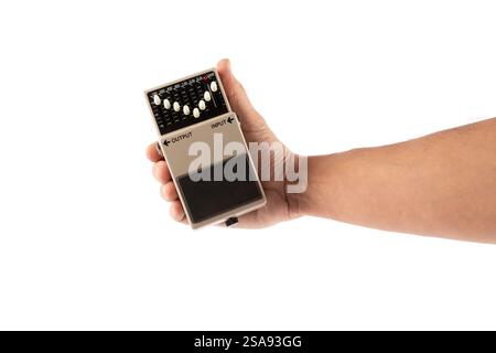 Male hand holding grey guitar effects pedal isolated on white background cutout Stock Photo