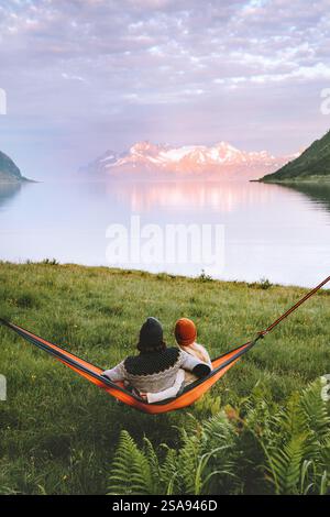 Couple in love hugging in hammock man and woman traveling together in Norway family vacations lifestyle summer camping outdoor boyfriend and girlfrien Stock Photo