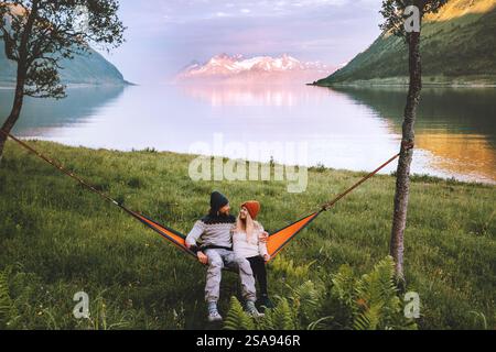 Couple friends chilling in hammock together man and woman traveling together in Norway family lifestyle summer vacations boyfriend and girlfriend roma Stock Photo