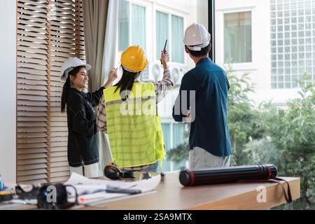 Construction team collaborating on project planning in a modern workspace. Stock Photo