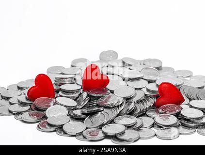 Scattered silver coins and several red hearts isolated on white. Idea for design. Valentine's Day card Stock Photo