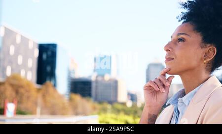 Thoughtful Young Woman in Professional Attire Standing Outdoors in Urban Setting Stock Photo