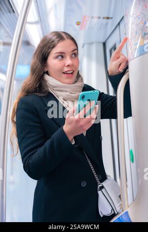 Young Woman Checking Subway Map While Using Smartphone.Vertical Stock Photo