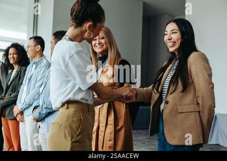 Diverse group of professionals networking and shaking hands at a business meeting, showcasing teamwork, collaboration, and connection. Stock Photo