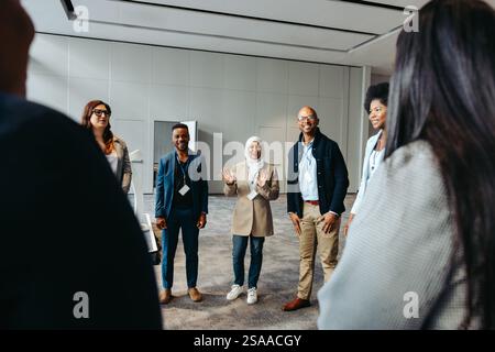 A diverse team talking and engaging in teambuilding activities in a modern office. Ideal for business and collaborative themes. Stock Photo