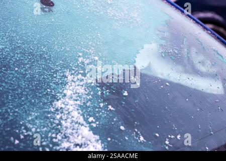 A detailed close up view of a car windshield that is completely covered in a layer of frost and snow, showcasing the cold effects of winter Stock Photo