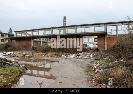 Remains of an old chemical factory looted dilapidated crumbling puddle water Stock Photo