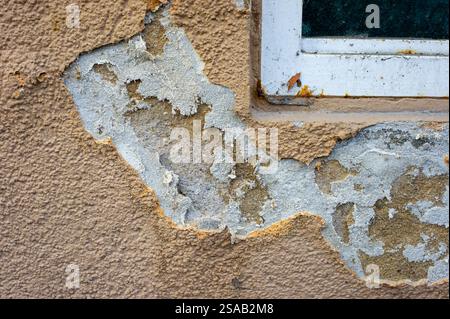 old wall with peeling paint and salpeter under the window Stock Photo