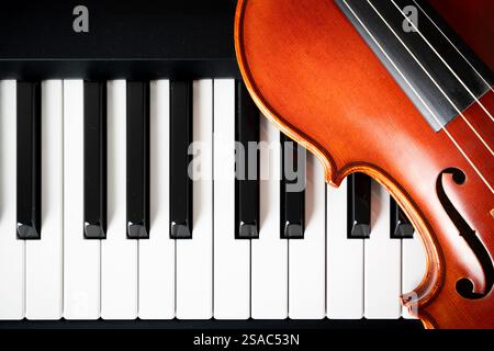 Violin on top of piano keyboard background with copy space for music concept or orchestra concert performance. Stock Photo