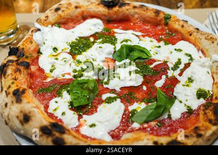 Delicious Italian pizza with burrata, fresh basil and pesto sauce Stock Photo