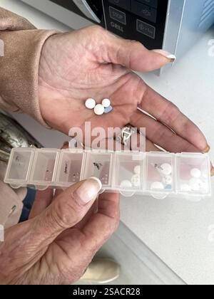 Mature woman’s hands with pills and pillbox Stock Photo