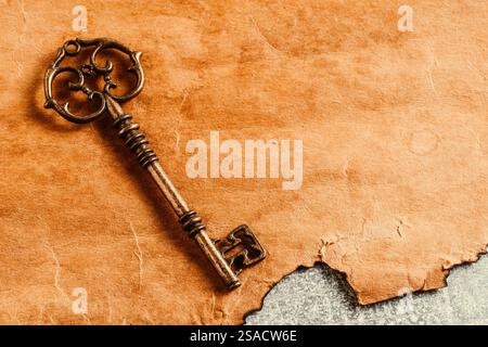 Vintage key on old paper background with copy space for text Stock Photo