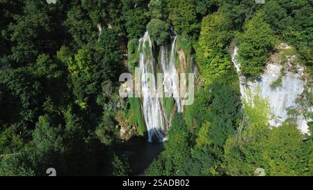 Aerial drone footage of Cascade de Glandieu Brégnier-Cordon France stunning multi-tiered natural waterfall cascading over moss-covered limestone rock Stock Photo