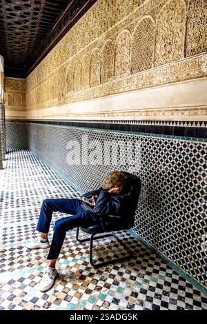Young man using cell phone in Merinide Abu al Hassan medersa, Sale, Morocco Stock Photo
