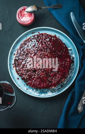 Cherry chocolate clafutis on a light blue plate on a dark background. French pie according to a traditional recipe. A quick homemade dessert. Vertical Stock Photo