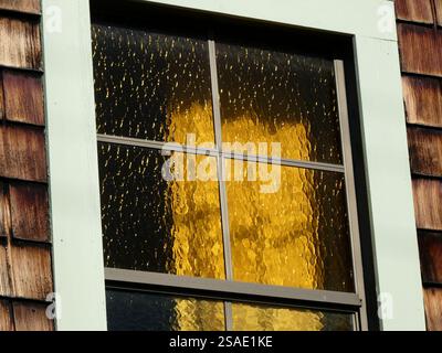 Objects behind ornate windows with golden textured glass panes in the afternoon light Stock Photo