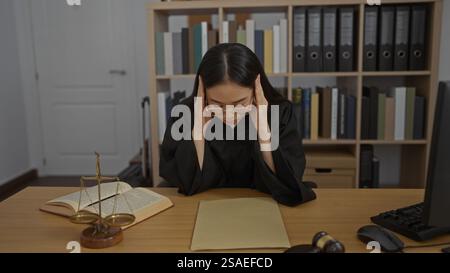 Stressed woman judge in office workplace indoors reading legal documents with glasses Stock Photo