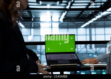 Computer scientists in data center using isolated screen mockup laptop to do network virtualization. Green screen chroma key notebook used by workers in server farm verifying rackmounts settings Stock Photo