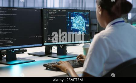 Engineer in data center implementing advanced AI driven predictive maintenance systems to proactively identify and resolve potential hardware failures before they impact operations, camera A Stock Photo