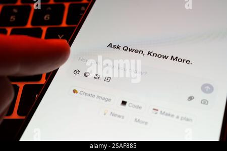 Alibaba's Qwen AI interface seen on the screen of smartphone placed on keyboard and finger pointing at it. Concept. Stafford, UK, January 29, 2025 Stock Photo