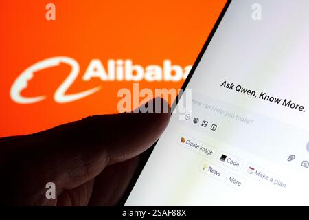 Qwen AI interface seen on the screen of smartphone hold in hand and blurred Alibaba logo on the background. Stafford, UK, January 29, 2025 Stock Photo