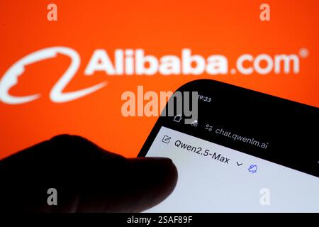 Qwen AI interface seen on the screen of smartphone hold in hand and blurred Alibaba logo on the background. Stafford, UK, January 29, 2025 Stock Photo