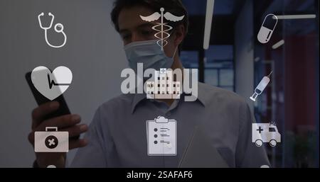 Image of medical icons over smiling caucasian businessman in facemask using smartphone Stock Photo