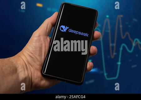 Man's hand holding mobile phone with Deepseek logo displayed Stock Photo
