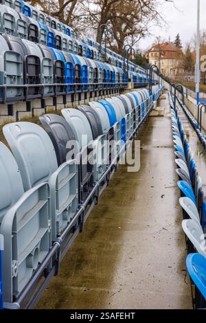 Aisle between blue and grey numbered seats in a stadium. Folded seats in a stadium. Stock Photo