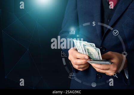 Young businessman with money on dark background. Concept of goals Stock Photo
