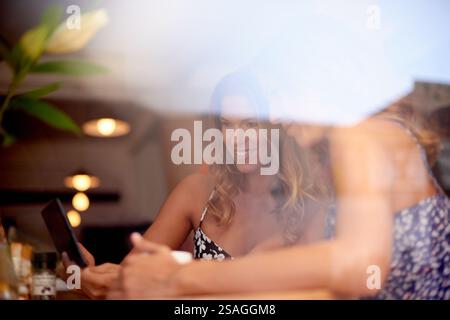 Tablet, window and women in cafe, conversation and planning for design project, brainstorming and ideas. Business people, creativity and freelancers Stock Photo
