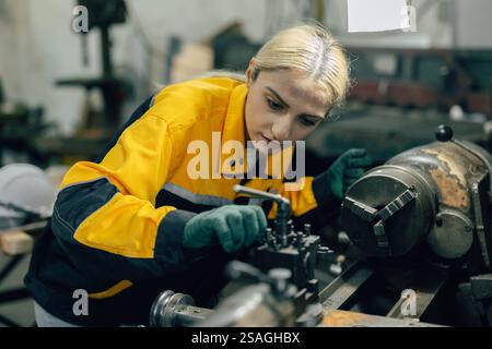 caucasian women worker working in heavy metal industry factory with steel part lathe machine Stock Photo