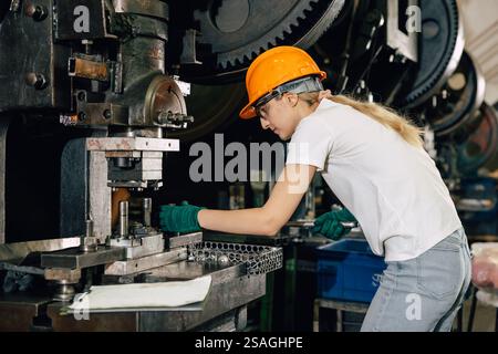 female technician worker working in heavy industry factory fixing service maintenance old machine Stock Photo
